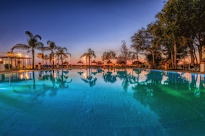 Piscine couverte, piscine extérieure, parasols de plage, chaises longues