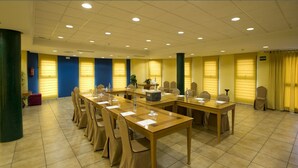 A conference room with multiple tables and chairs, equipped with water bottles and notepads. - Louty Simba (Chilches)