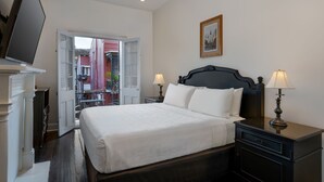 A neatly made bed with white linens, a dark headboard, and two bedside lamps. - Hotel Royal (New Orleans)