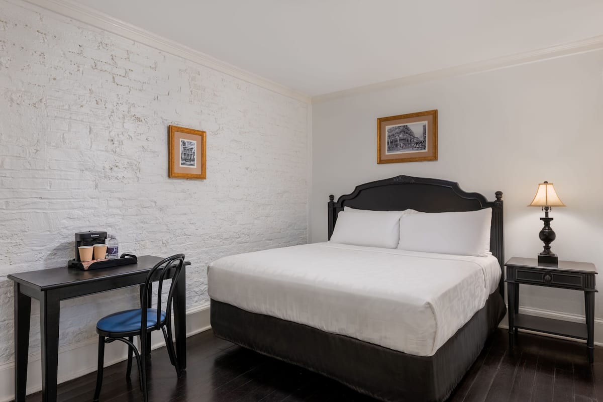 Classic hotel room with a large bed, desk, and comfortable seating area.