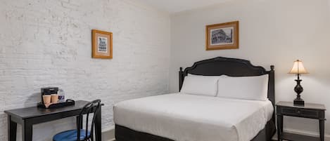 A bedroom with a bed, a desk, a chair, and two nightstands.