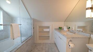 Un baño moderno con bañera, un espejo grande, tocador con lavabo y zona de ducha.