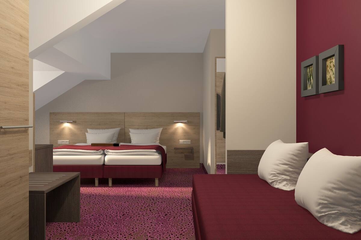 A bedroom with a bed, a desk, and a chair.