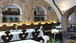 A restaurant with stone walls, wooden furniture, and potted plants. - Mayerhofer - Hotel - Restaurant - Partyservice - Tagung (Aldersbach)