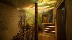 A hallway with a mural, a reception desk, and a staircase. - Flair Hotel Mellestollen (Saalfeld-Saale)