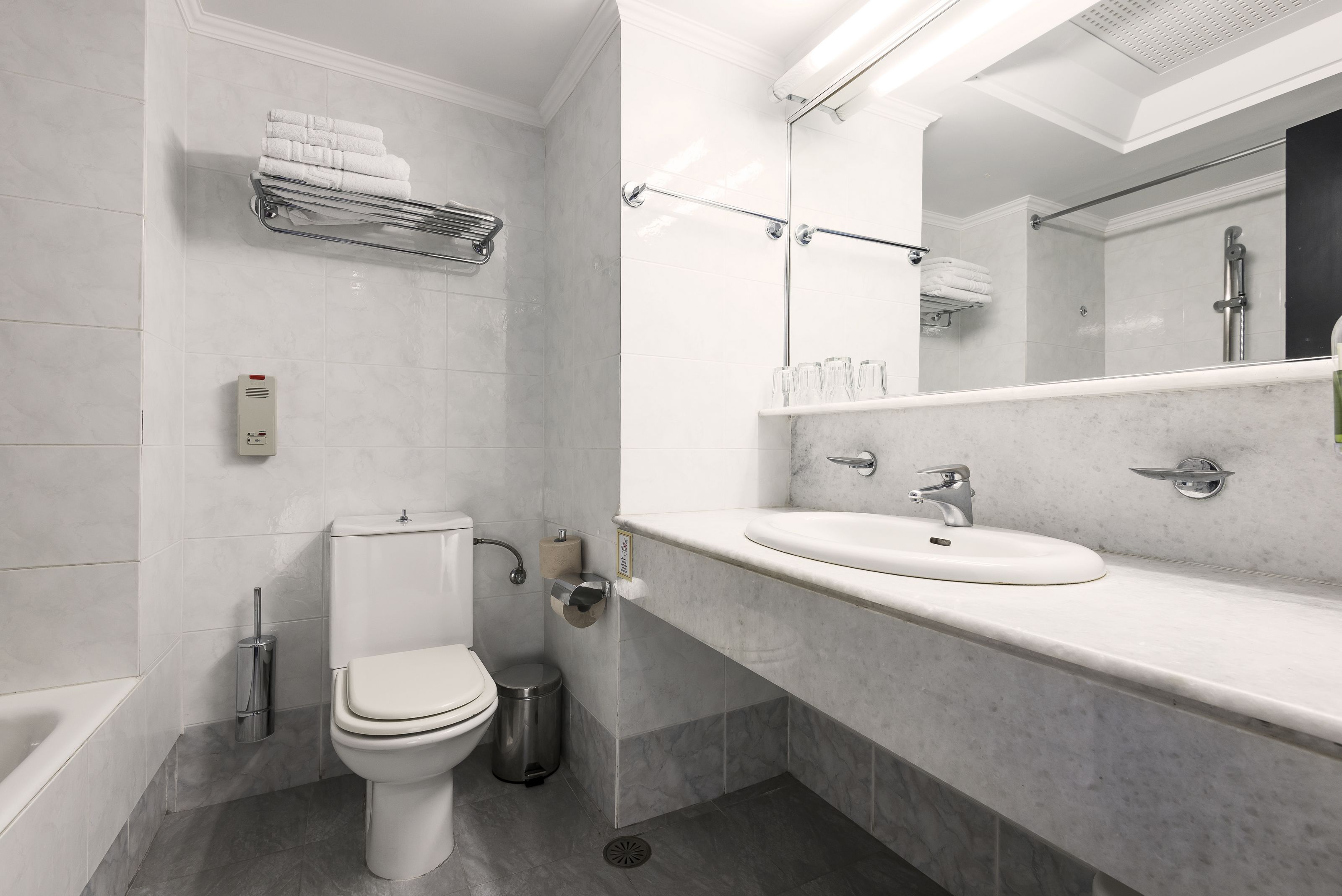A modern bathroom with a toilet, sink, and shower.