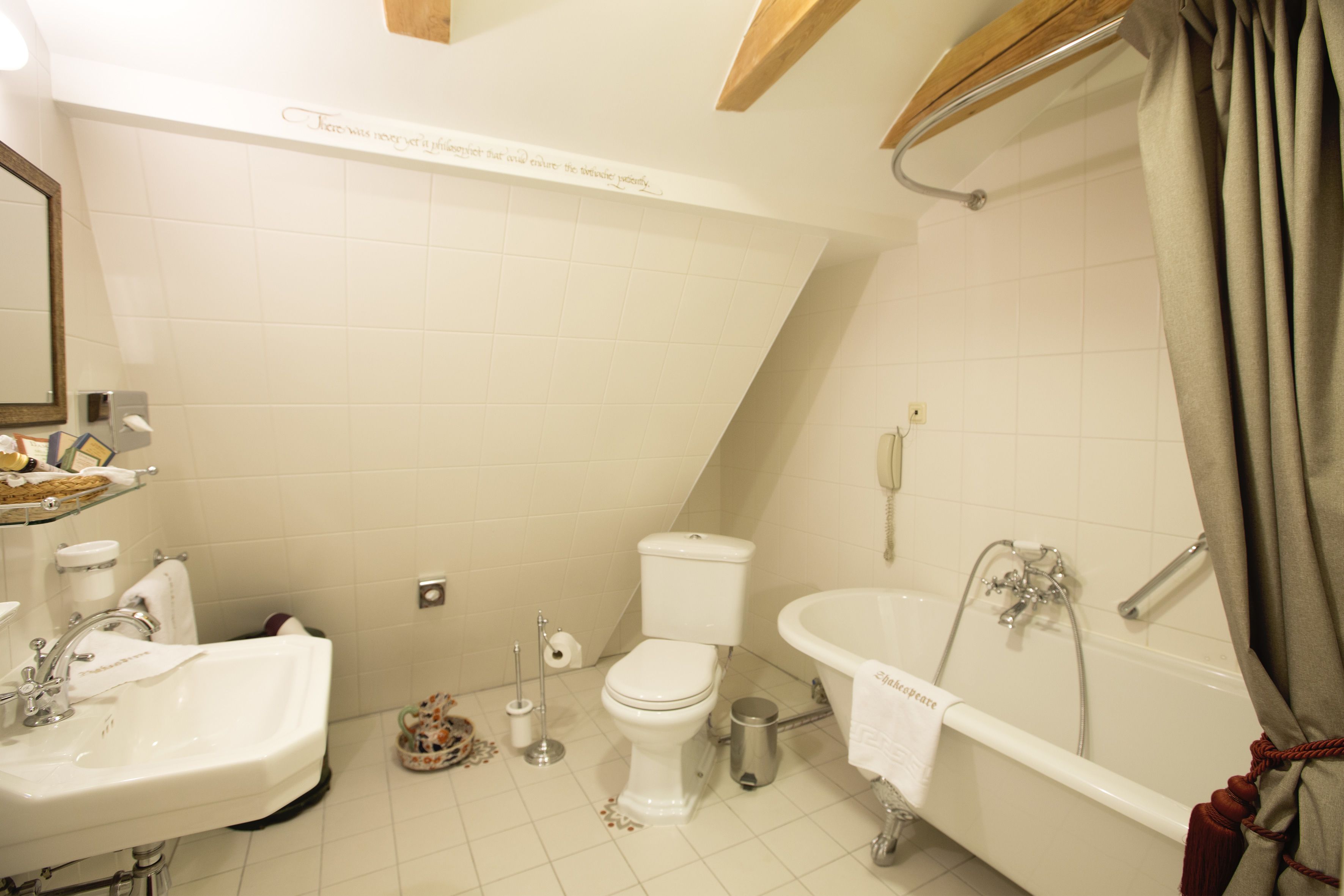 Et badeværelse med toilet, vask og badekar.