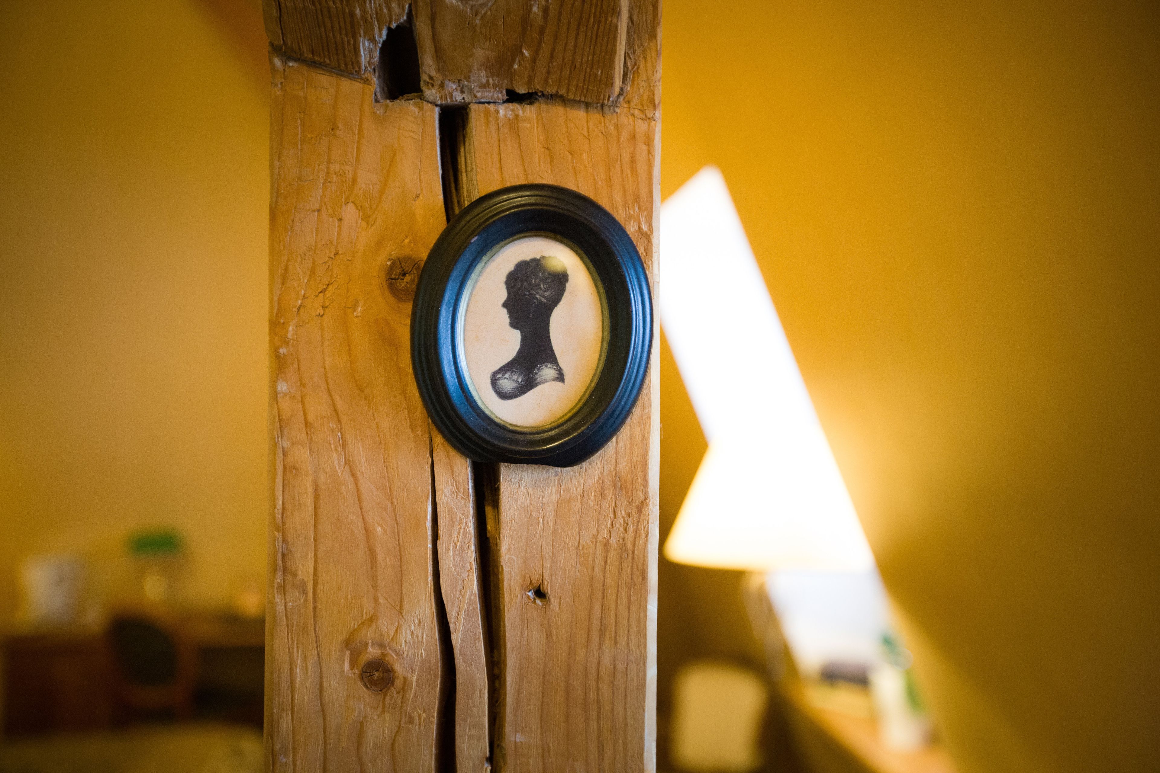 A wooden post with a circular object, possibly a decorative item, mounted on it.