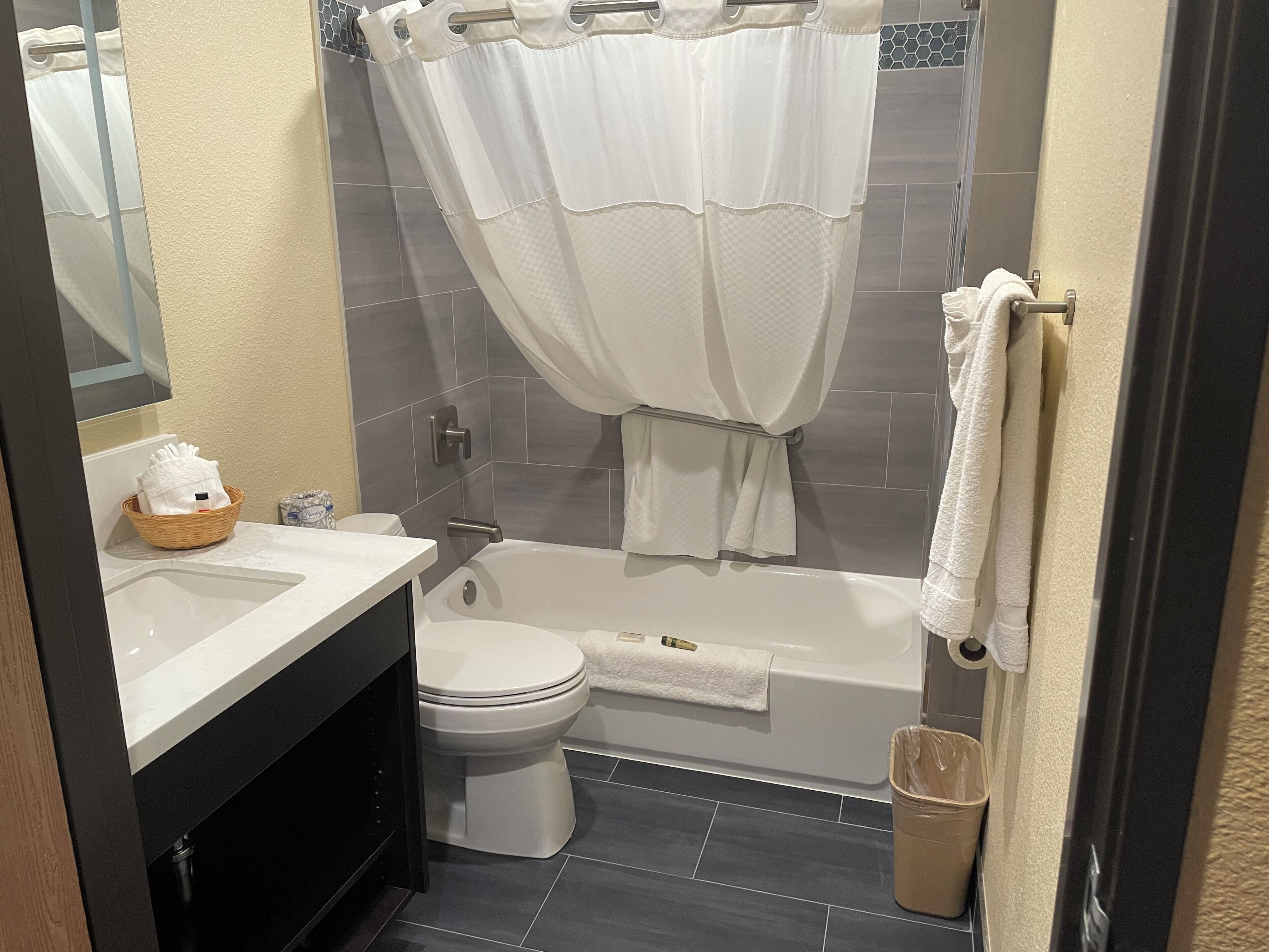 A bathroom with a toilet, bathtub, and a shower curtain.