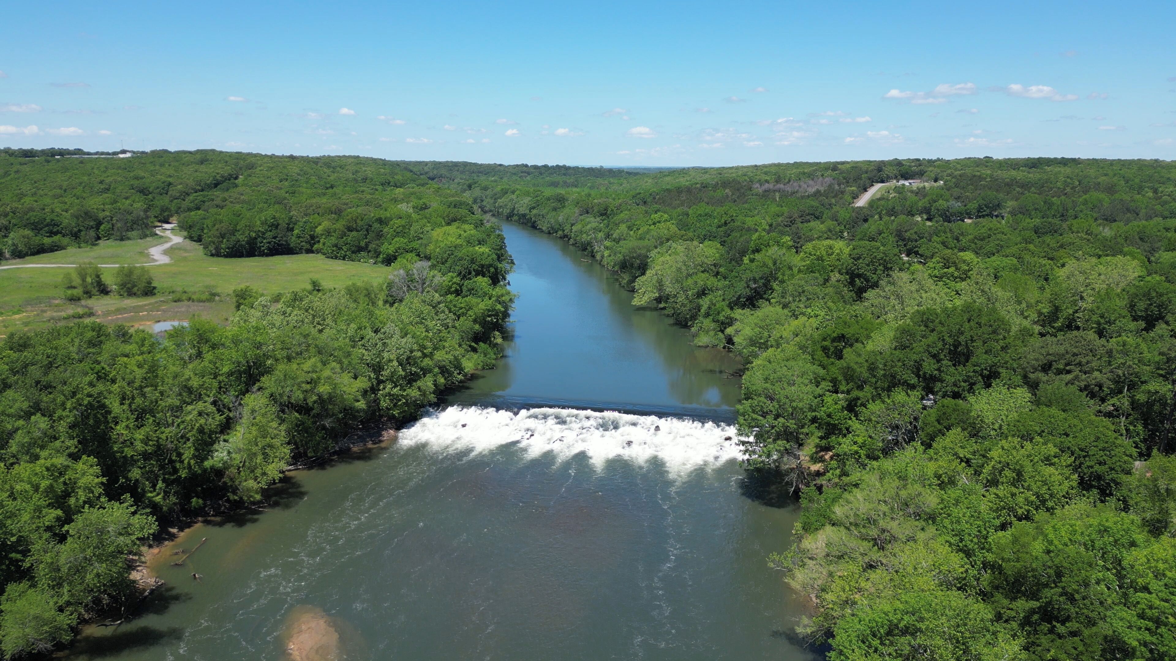 Un río que atraviesa una zona boscosa densa, con una cascada.