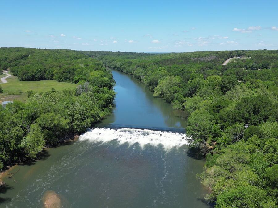 Un río que atraviesa una zona boscosa densa, con una cascada.