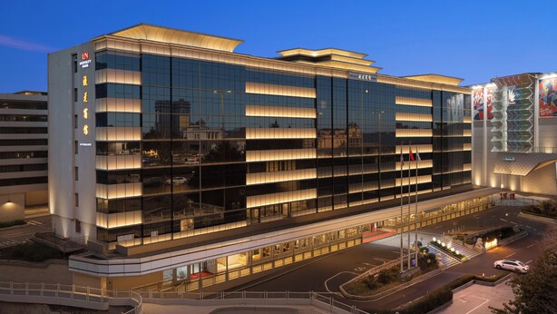 A modern hotel building with multiple floors, large windows, and a well-lit entrance. - Liuhua Hotel (Guangzhou)