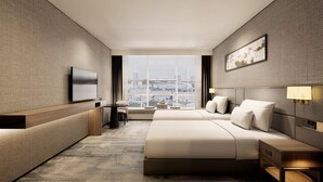 A modern hotel room with a large bed, a TV, a desk, and a view of the city. - Liuhua Hotel (Guangzhou)