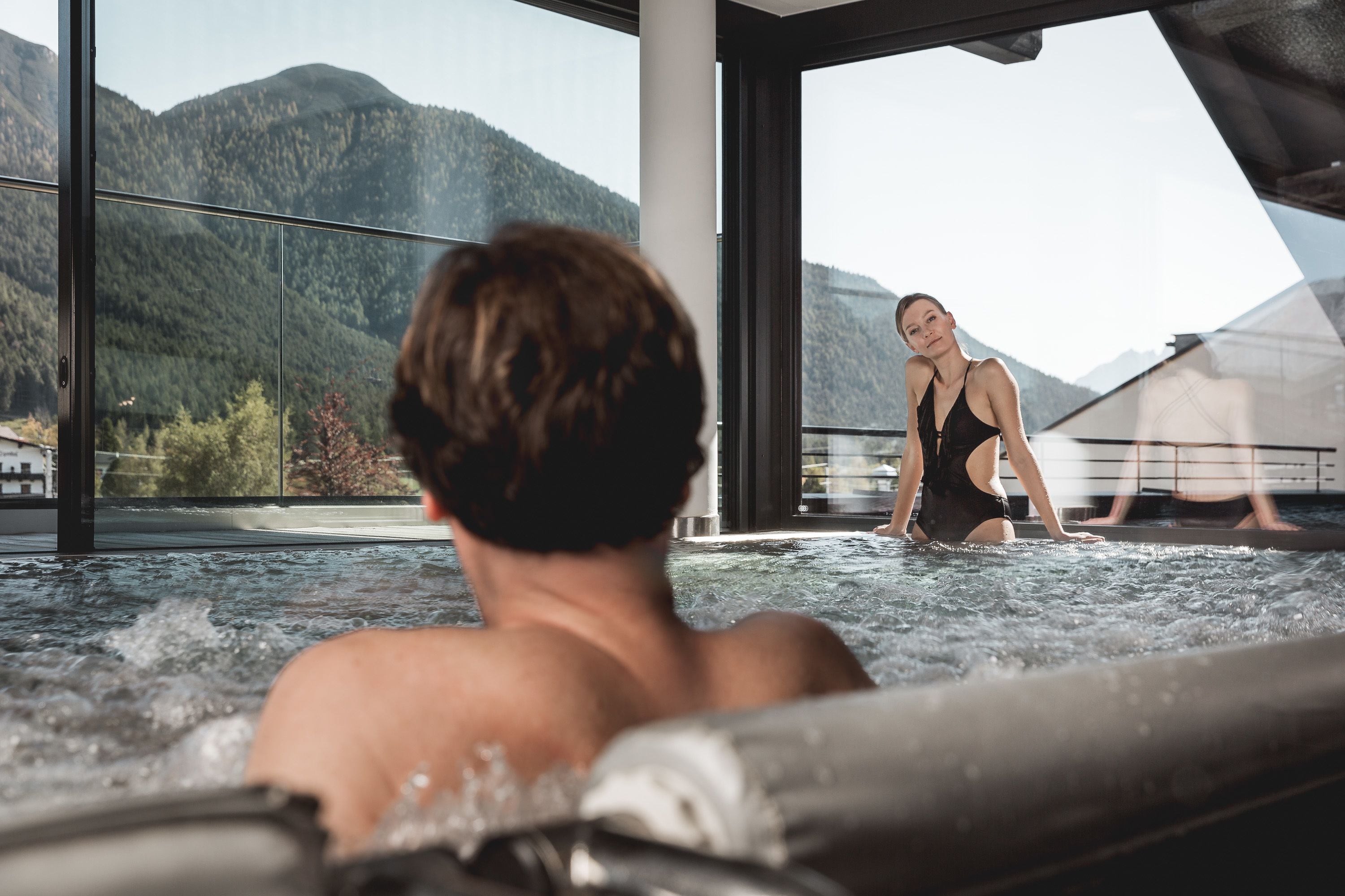 Un couple dans un jacuzzi avec vue sur la montagne.