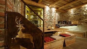 A rustic interior with exposed brick walls, wooden beams, and a stone fireplace.