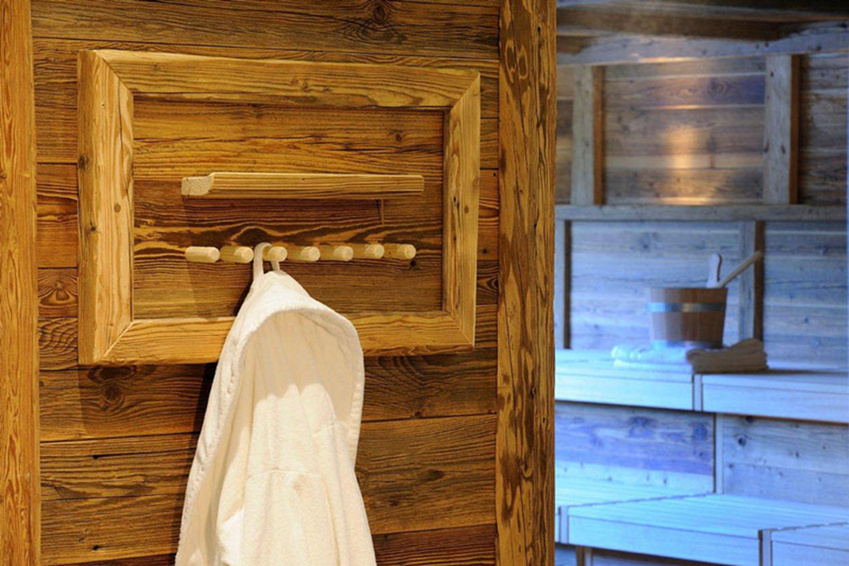 A wooden wall with a towel rack and a wooden cabinet.