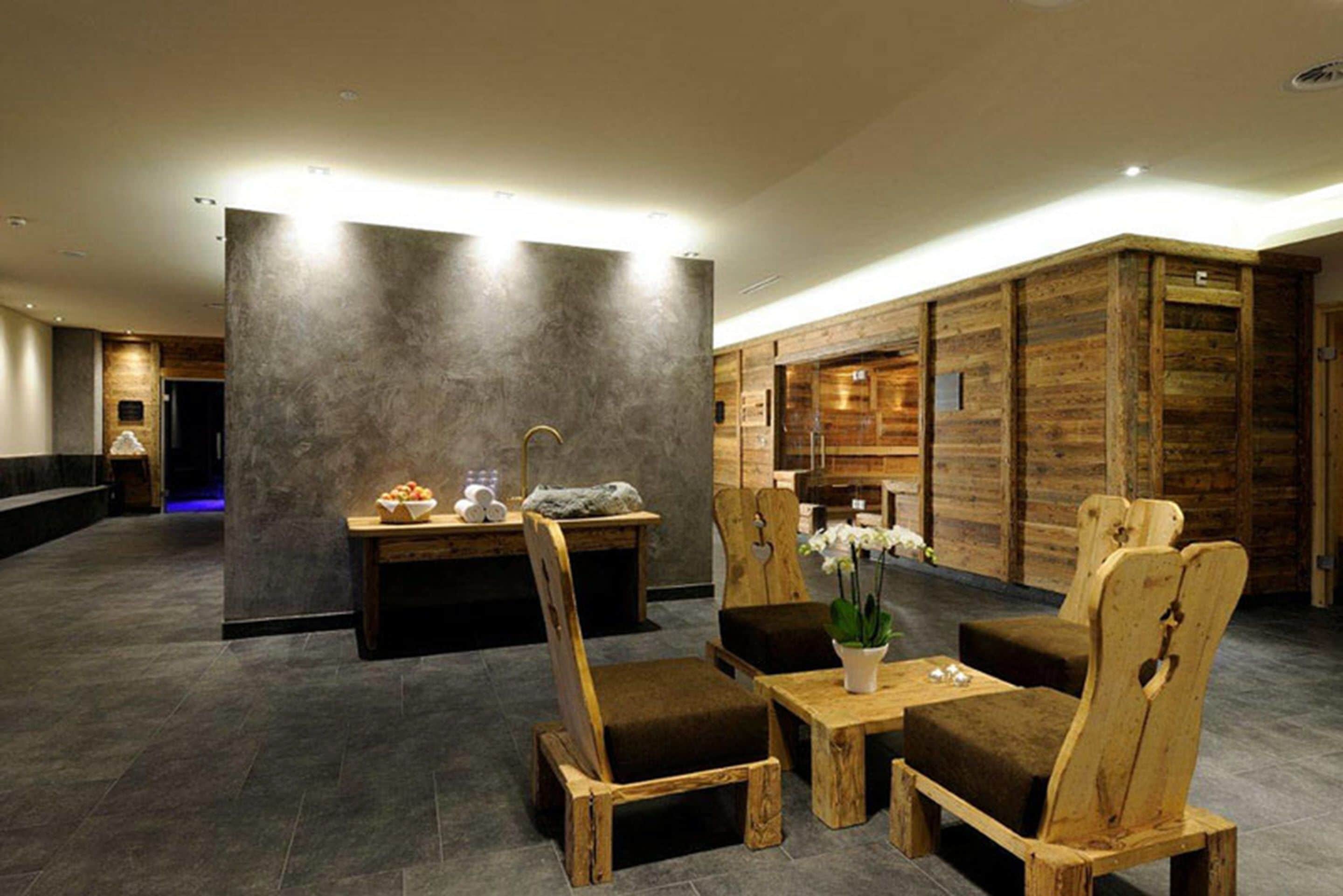 A lobby with wooden furniture, a reception desk, and a stone wall.