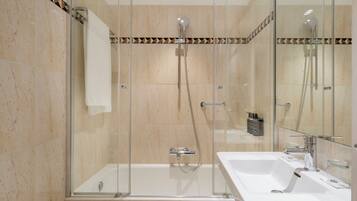 Un baño moderno con ducha de vidrio, una bañera blanca y un lavabo con espejo.