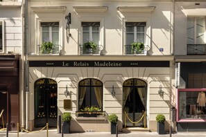 A building with a sign reading 'Le Relais Madeleine' and a black awning with gold detailing. - Le Relais Madeleine (Paris)