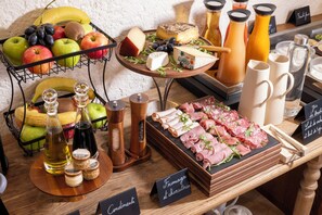 Una variedad de quesos, frutas y salsas sobre una mesa de madera.