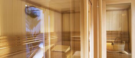A sauna with wooden benches and a bench with a towel.