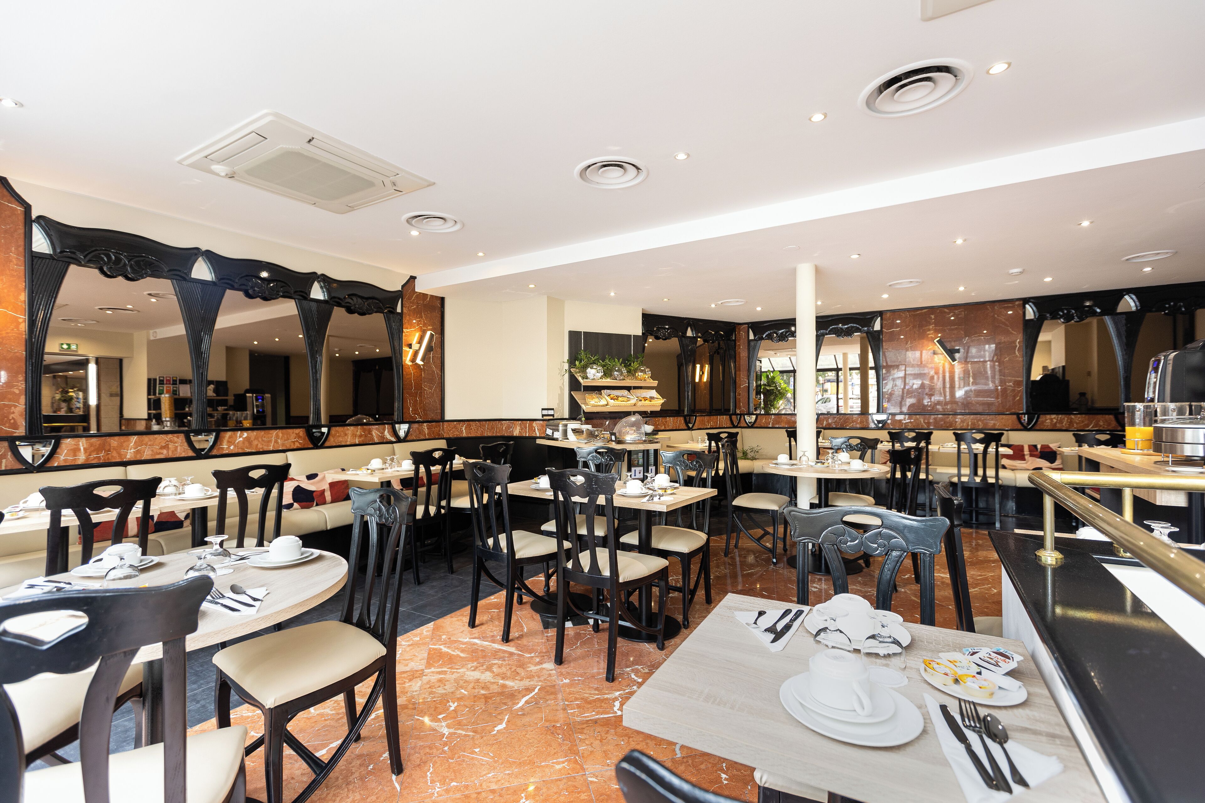 A restaurant with marble flooring, multiple dining tables, and chairs.
