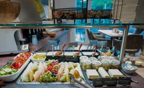 Een buffet met diverse etenswaren en labels voor biologische boter en andere producten.