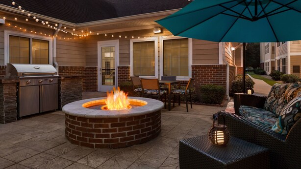 An outdoor patio area with a fire pit, grill, and seating. - Residence Inn by Marriott Houston Northwest/Willowbrook. (Houston)