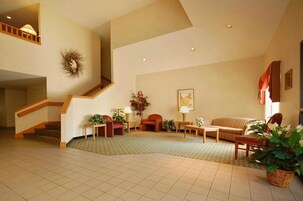 Un salón espacioso con una escalera, un sofá, una mesa de centro y una chimenea.