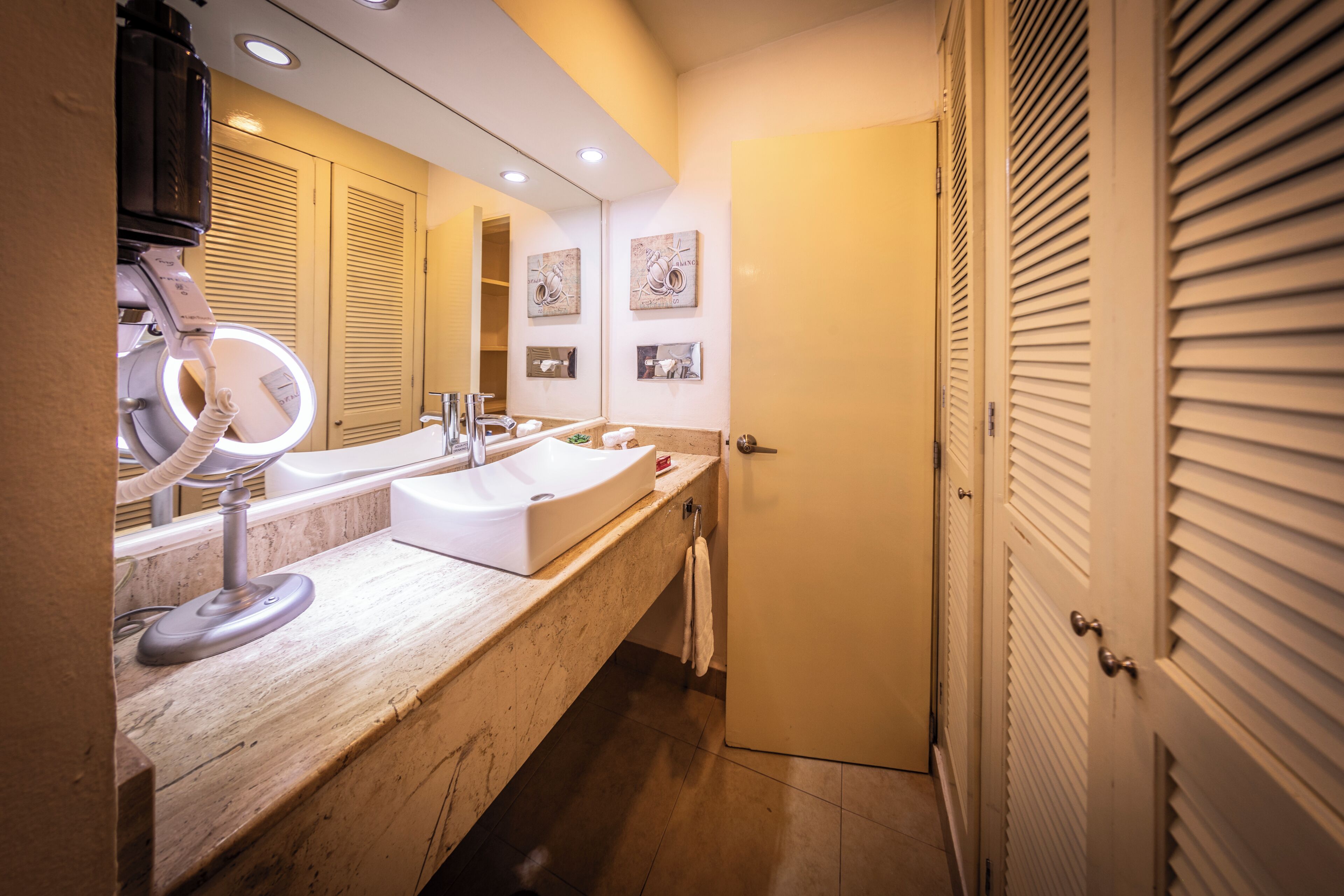 A bathroom with a vanity, mirror, and towel rack.