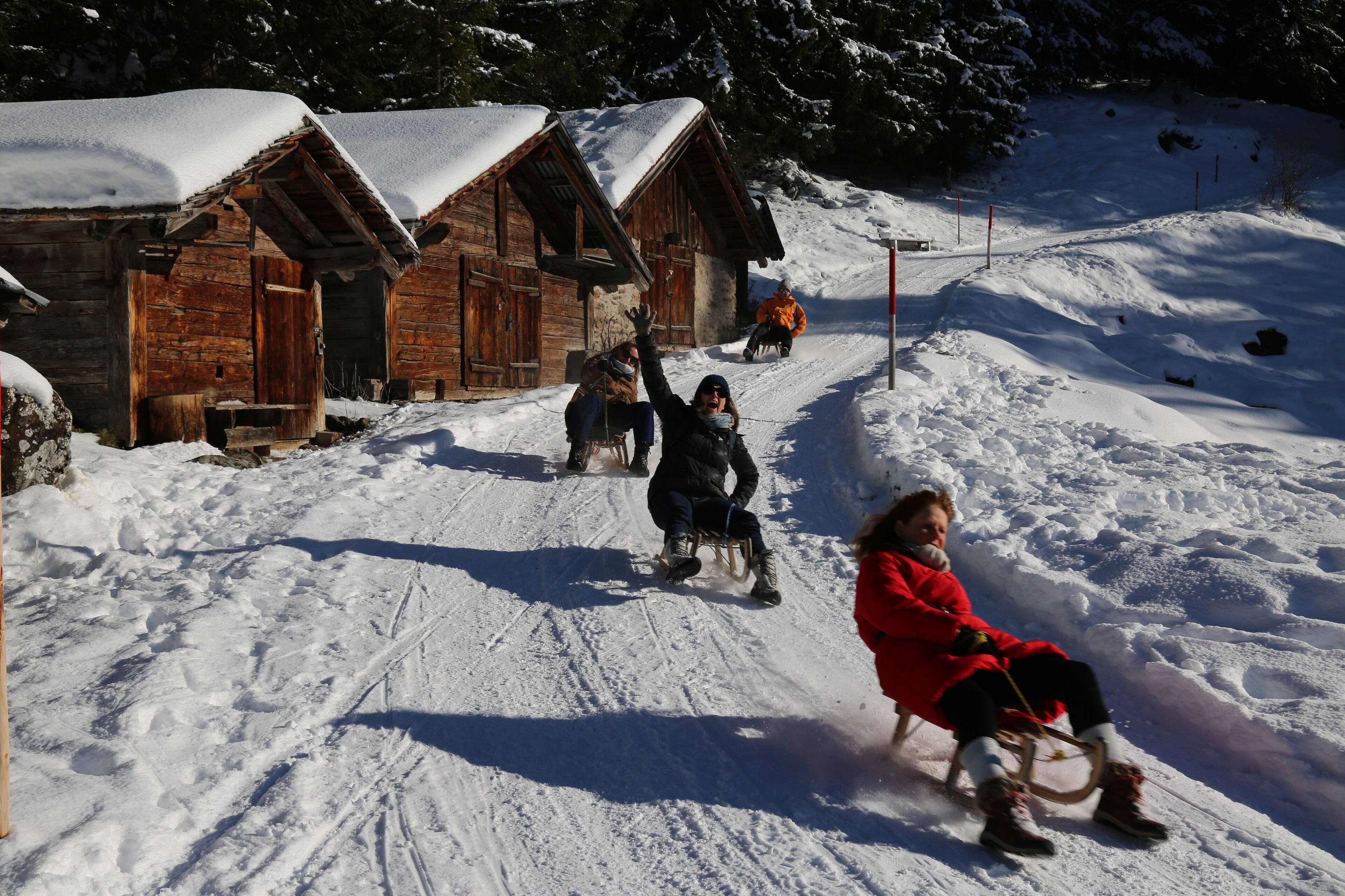 Un villaggio innevato con case di legno e una pista per slittino.