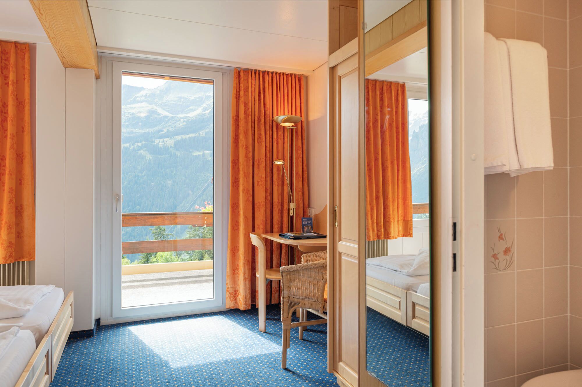 Une chambre d’hôtel avec un lit, un bureau, une chaise et une salle de bain.