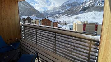 A balcony with a view of a snow-covered mountain and buildings.