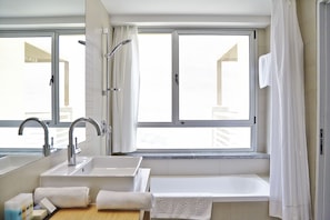 Een bad/douchecombinatie, gratis toiletartikelen, handdoeken