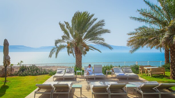 Un espace aménagé au bord de la piscine, avec des chaises longues et une personne qui se détend.