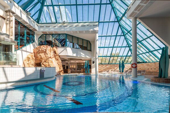 Piscine couverte, piscine extérieure, parasols de plage, chaises longues