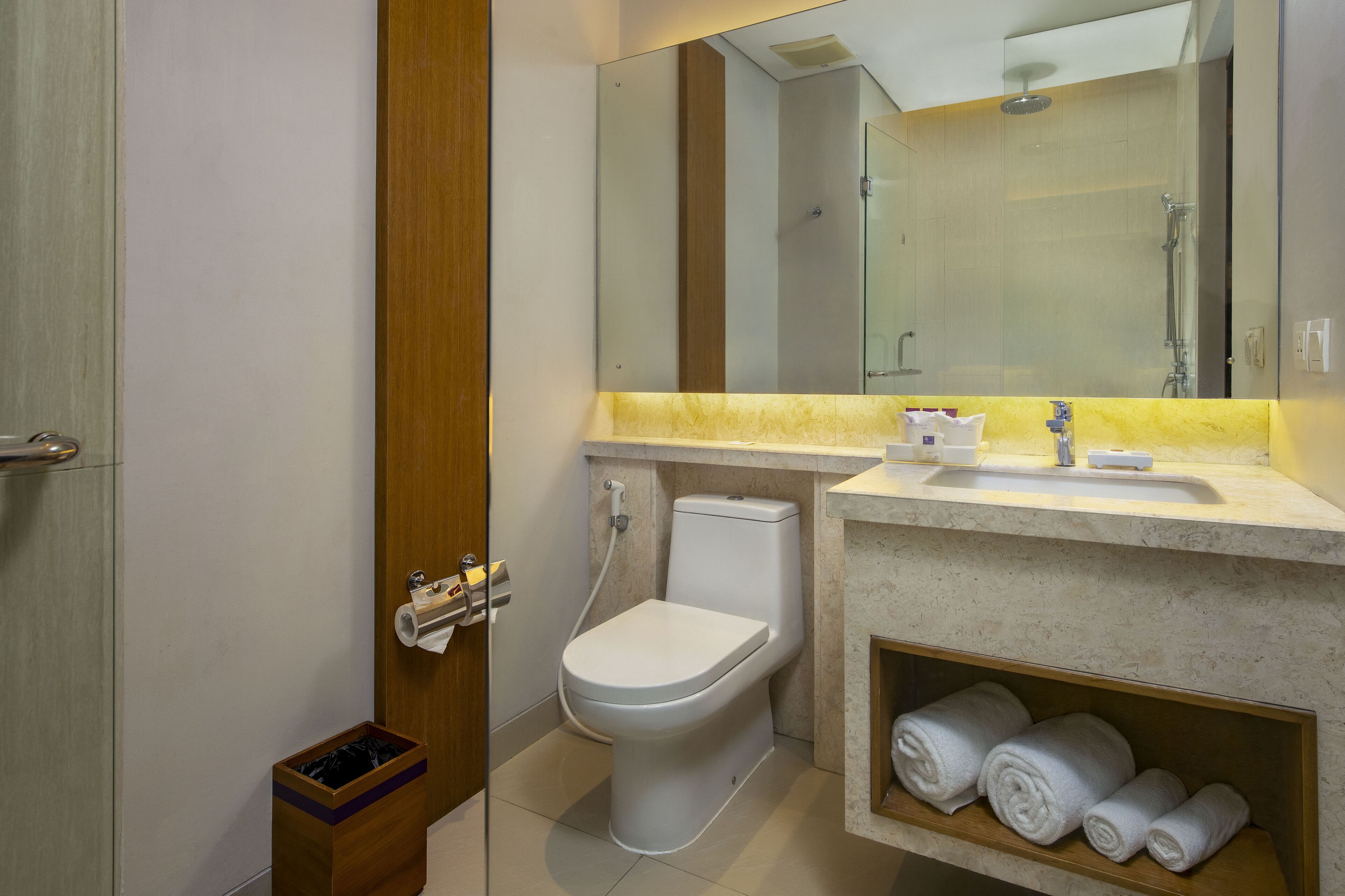 A modern bathroom with a toilet, sink, and mirror.