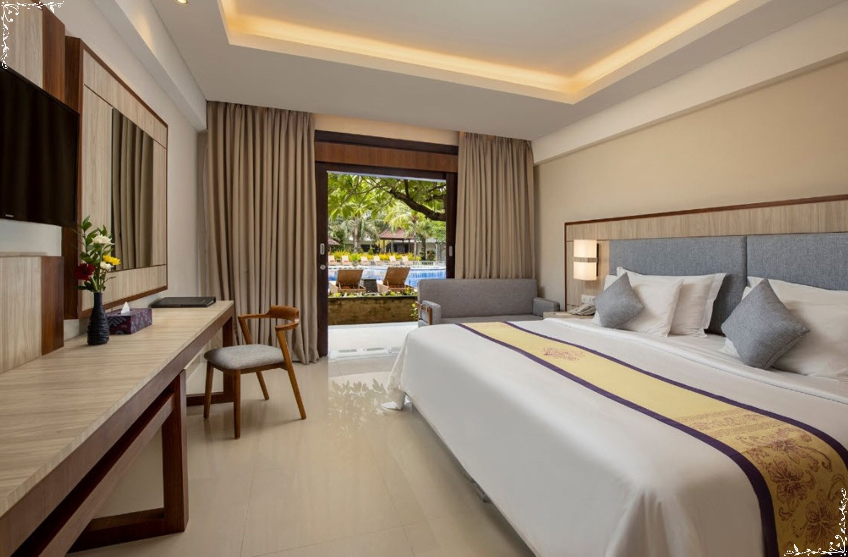 A hotel room with a large bed, a desk, and a view of an outdoor pool area.