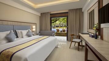 A hotel room with a large bed, a desk, a chair, and a view of a pool area.