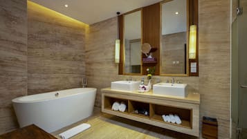 A modern bathroom with a freestanding bathtub, two sinks, and a vanity with shelves for towels.