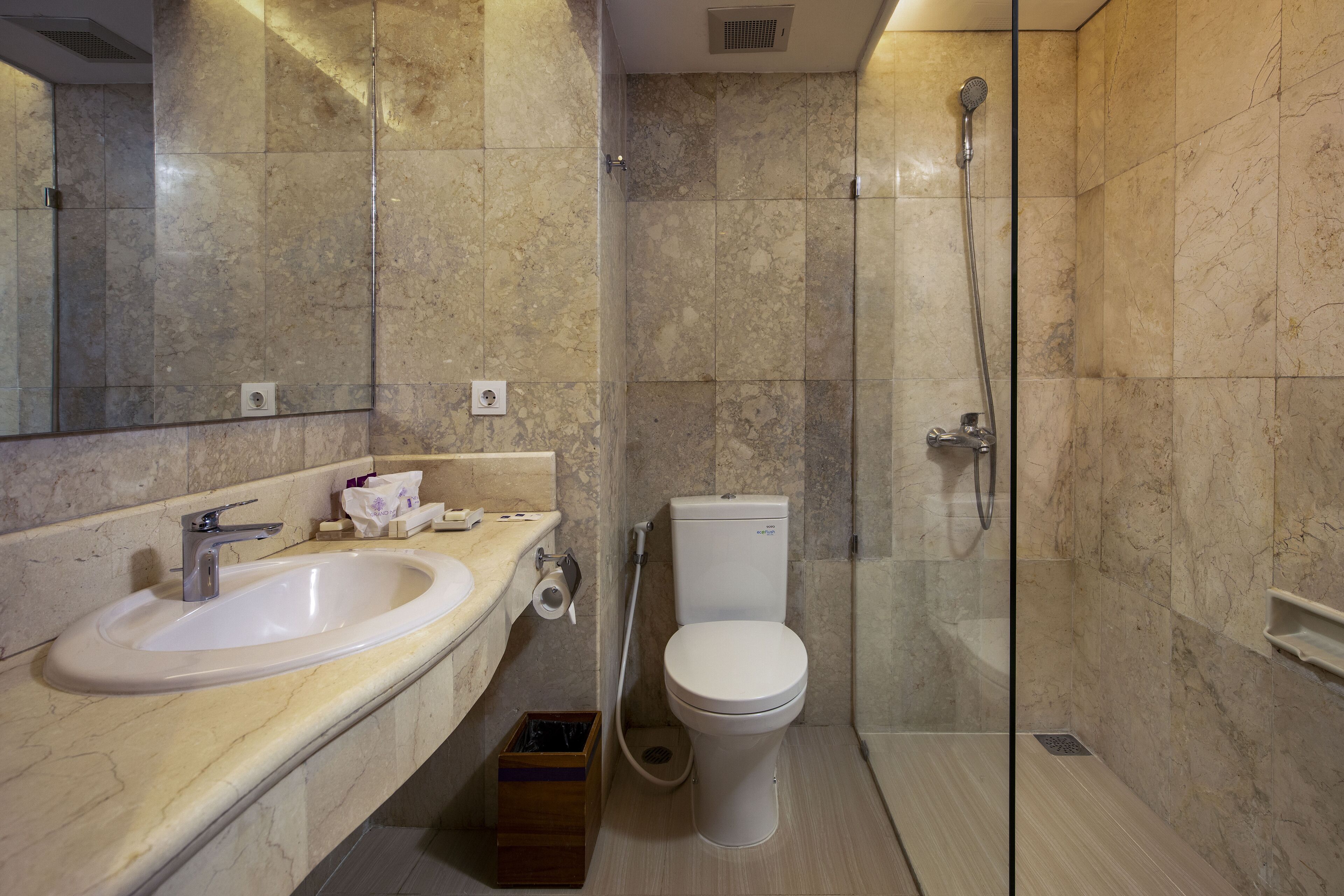 A bathroom with a sink, toilet, and glass-enclosed shower.