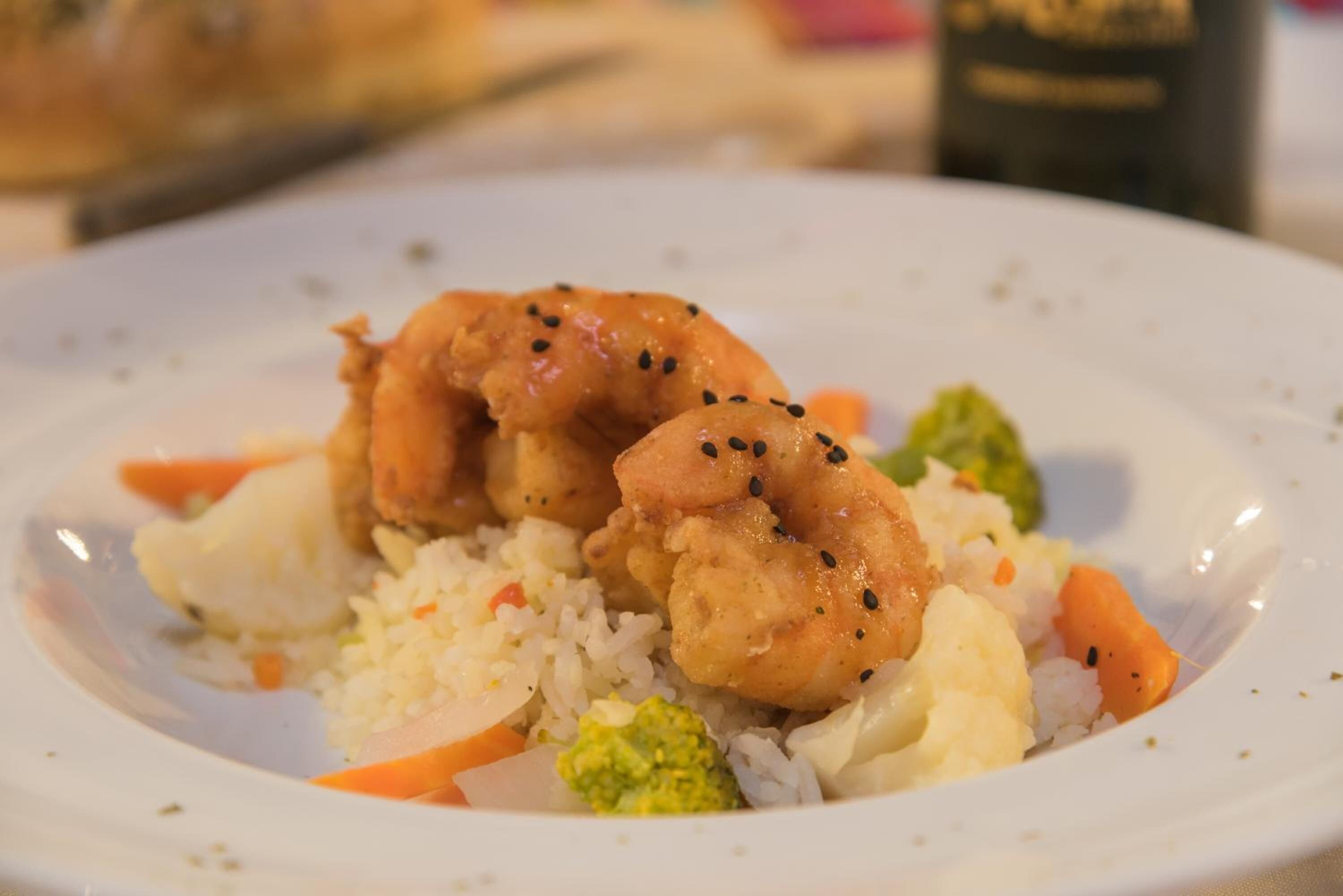 A plate with fried shrimp, rice, and vegetables.