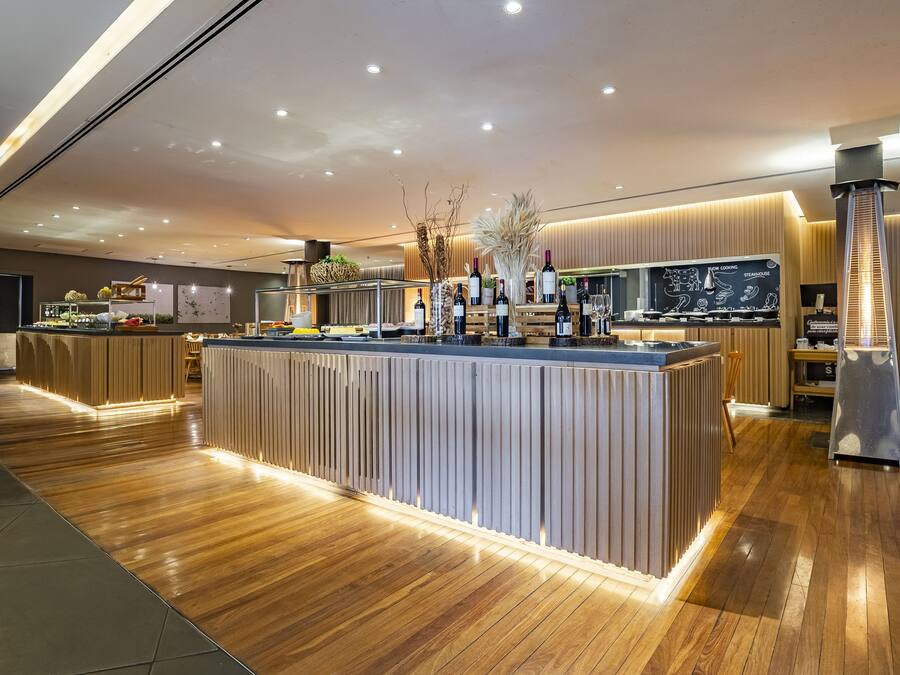 Eine moderne Hotelhalle mit einer zentralen Bar, Holzböden und zeitgenössischer Einrichtung.