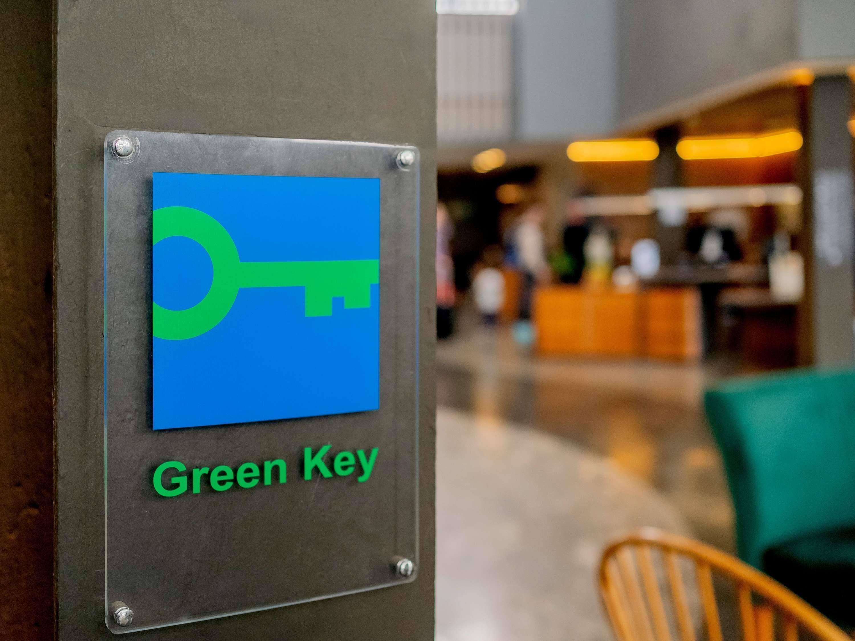 Une plaque métallique portant un symbole de clé et l’inscription « Green Key ».