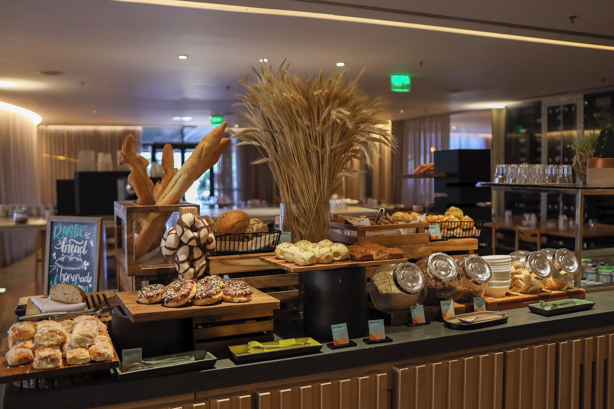 A bakery display with various baked goods and a sign indicating 'Rustic Bread Homemade'.