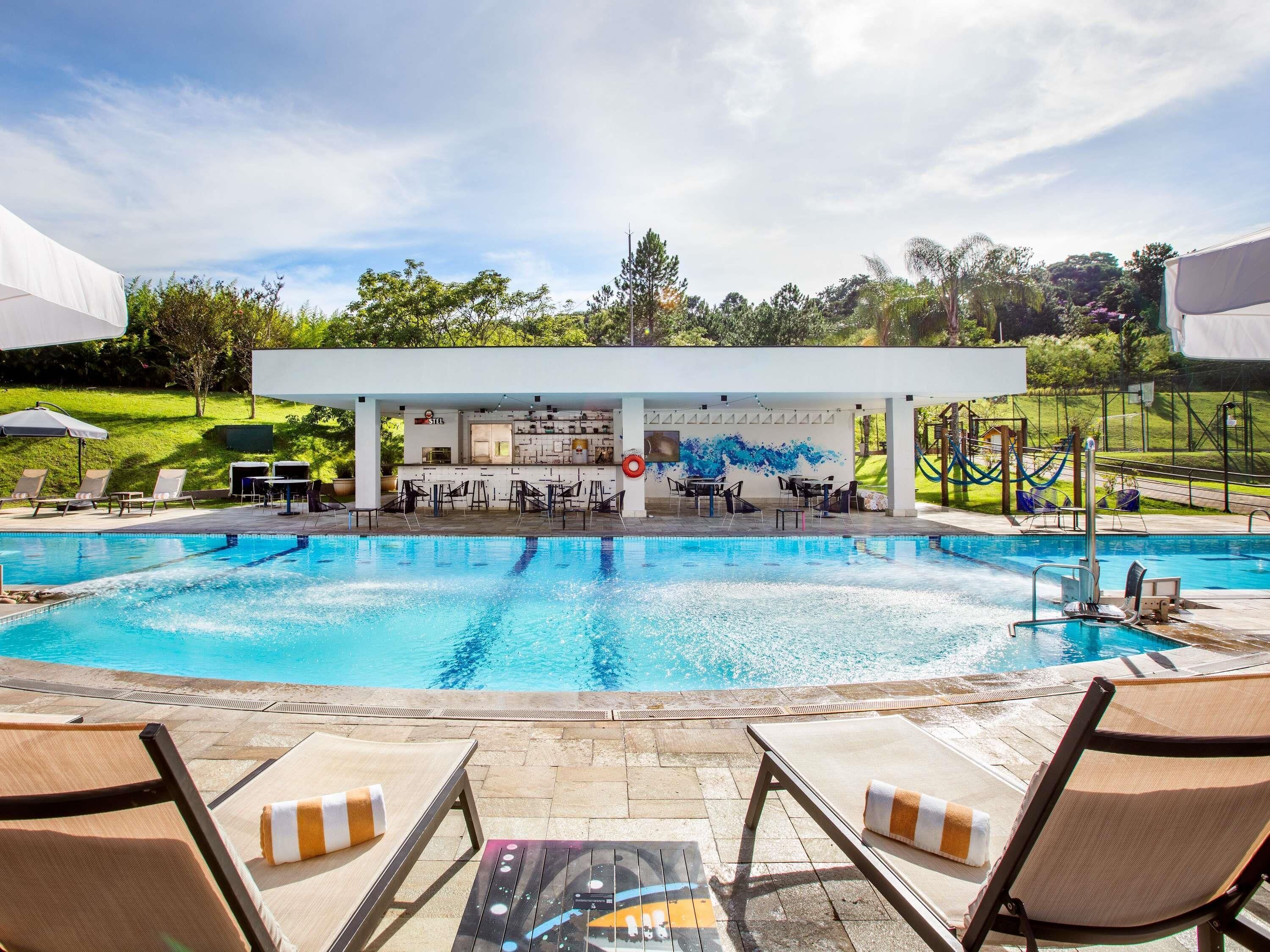 Alberca al aire libre, sombrillas en la alberca y camastros 