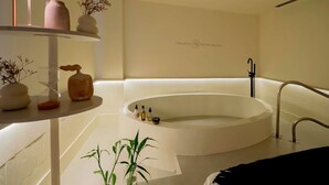 A modern bathroom with a freestanding bathtub, a shelf with decorative items, and a wall-mounted towel rack. - Pullman São Paulo Guarulhos Airport (Guarulhos)