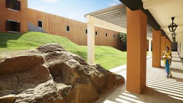 A modern building with a covered walkway and a rock formation.