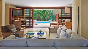 A gym with exercise equipment, large windows, and a view of greenery. at Viceroy Riviera Maya, a Luxury Villa Resort - Adults Only