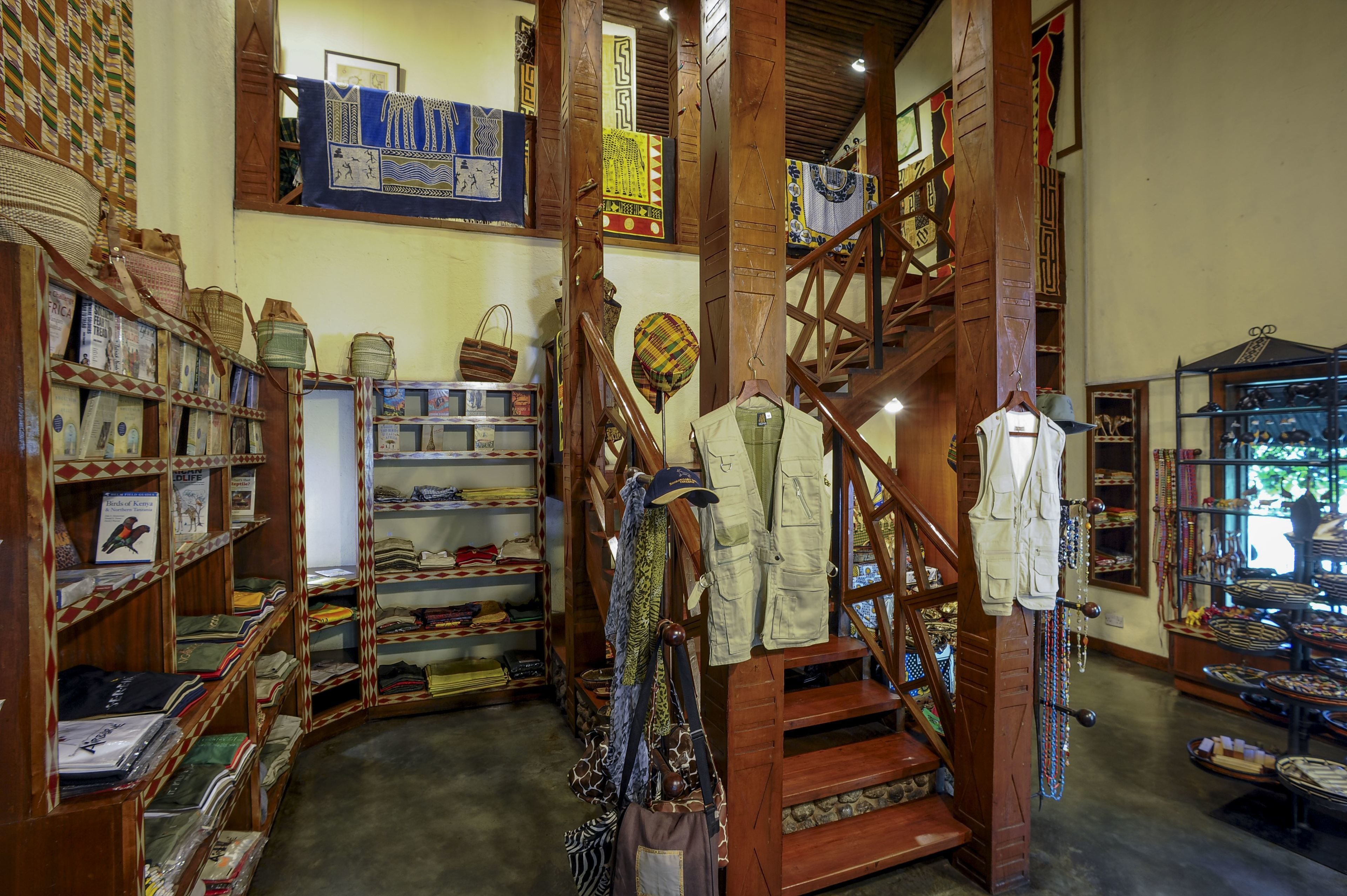 A traditional store with wooden shelves displaying textiles, bags, and accessories.